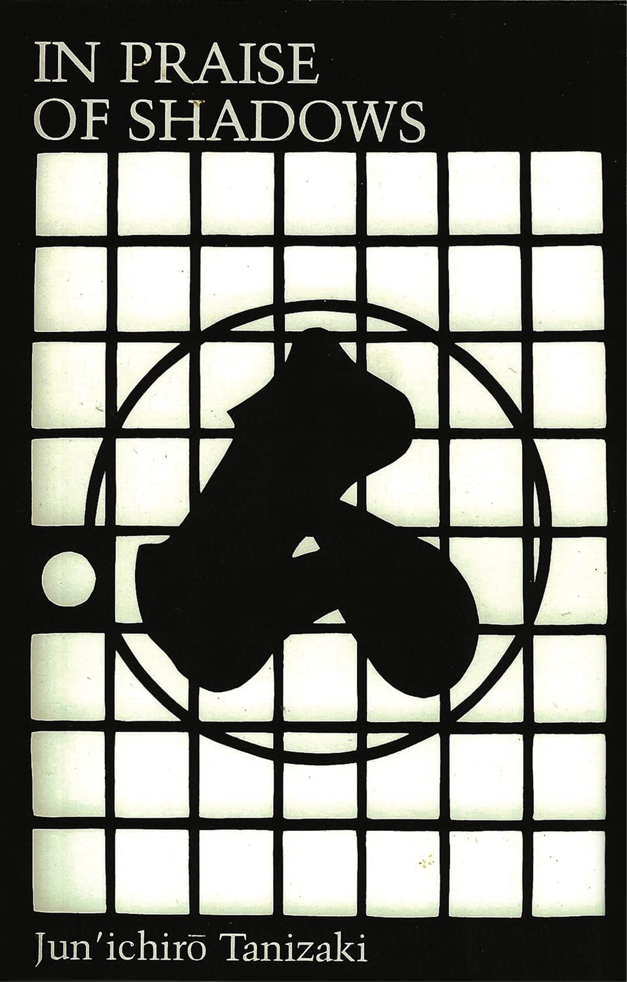 Cover of "In Praise of Shadows," featuring two circles and an amorphous black form on a white grid.