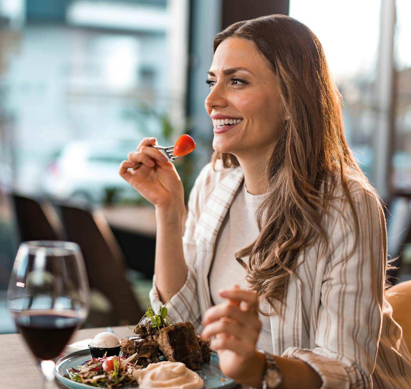 woman dining with a glass of wine in a restaurant