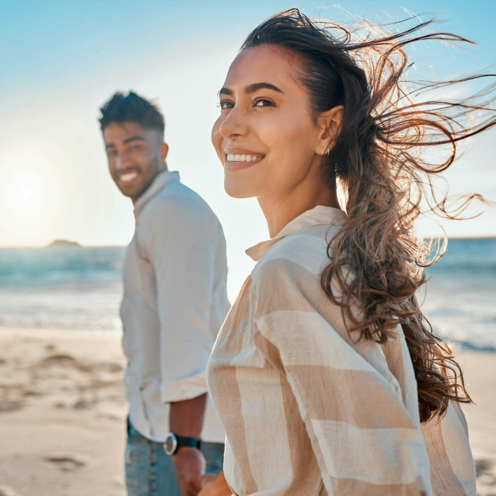 Woman smiling next to a man on the beach
