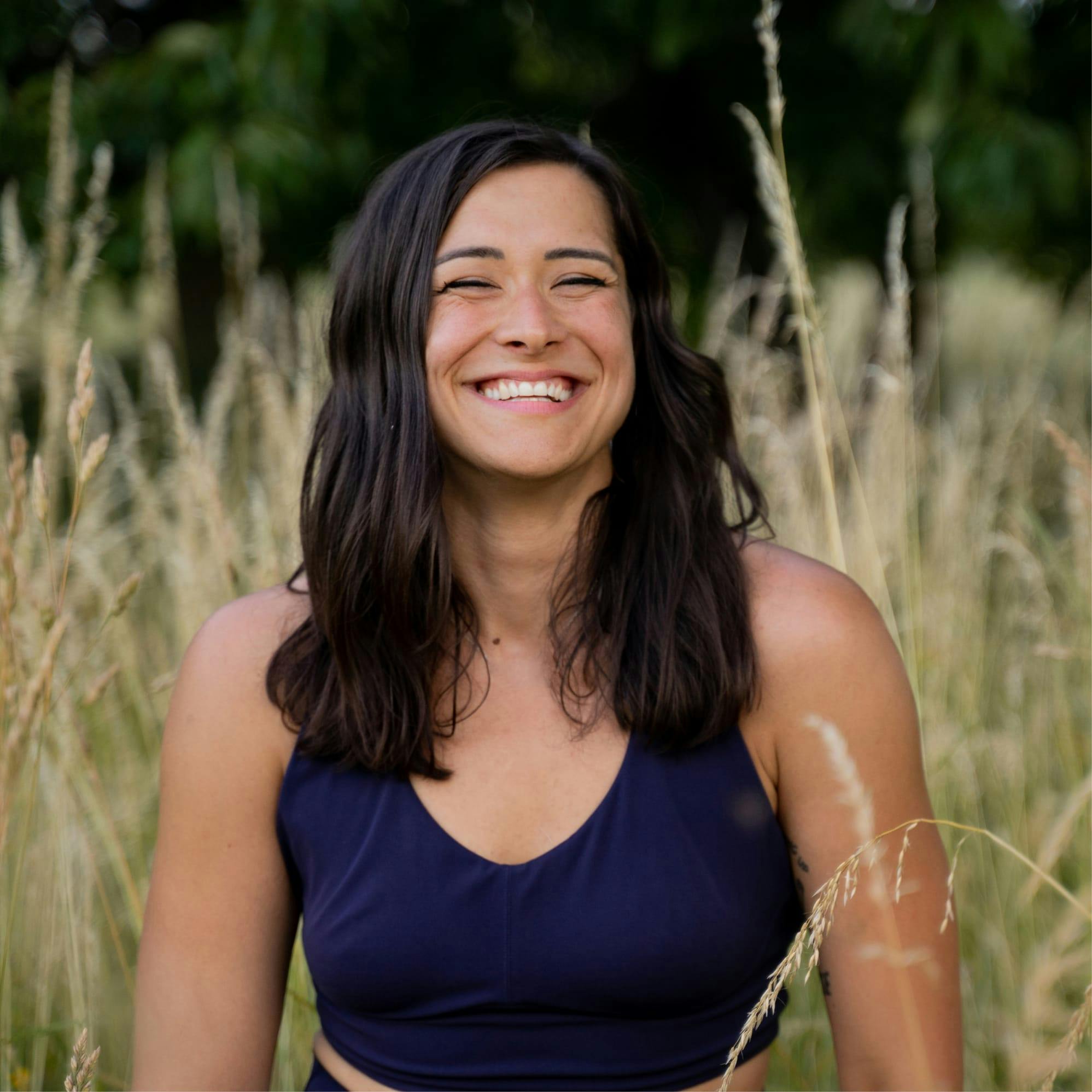 Woman standing in a field smiling