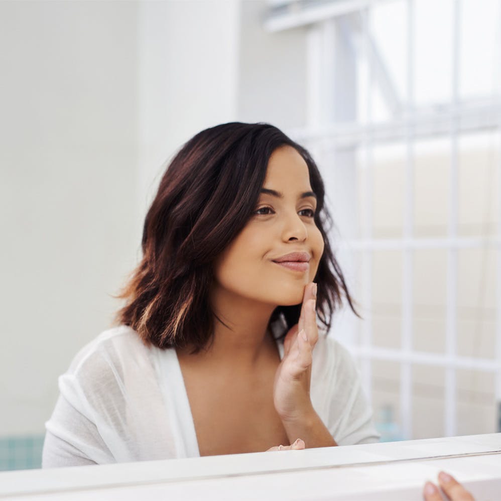 woman appliying makeup in mirror