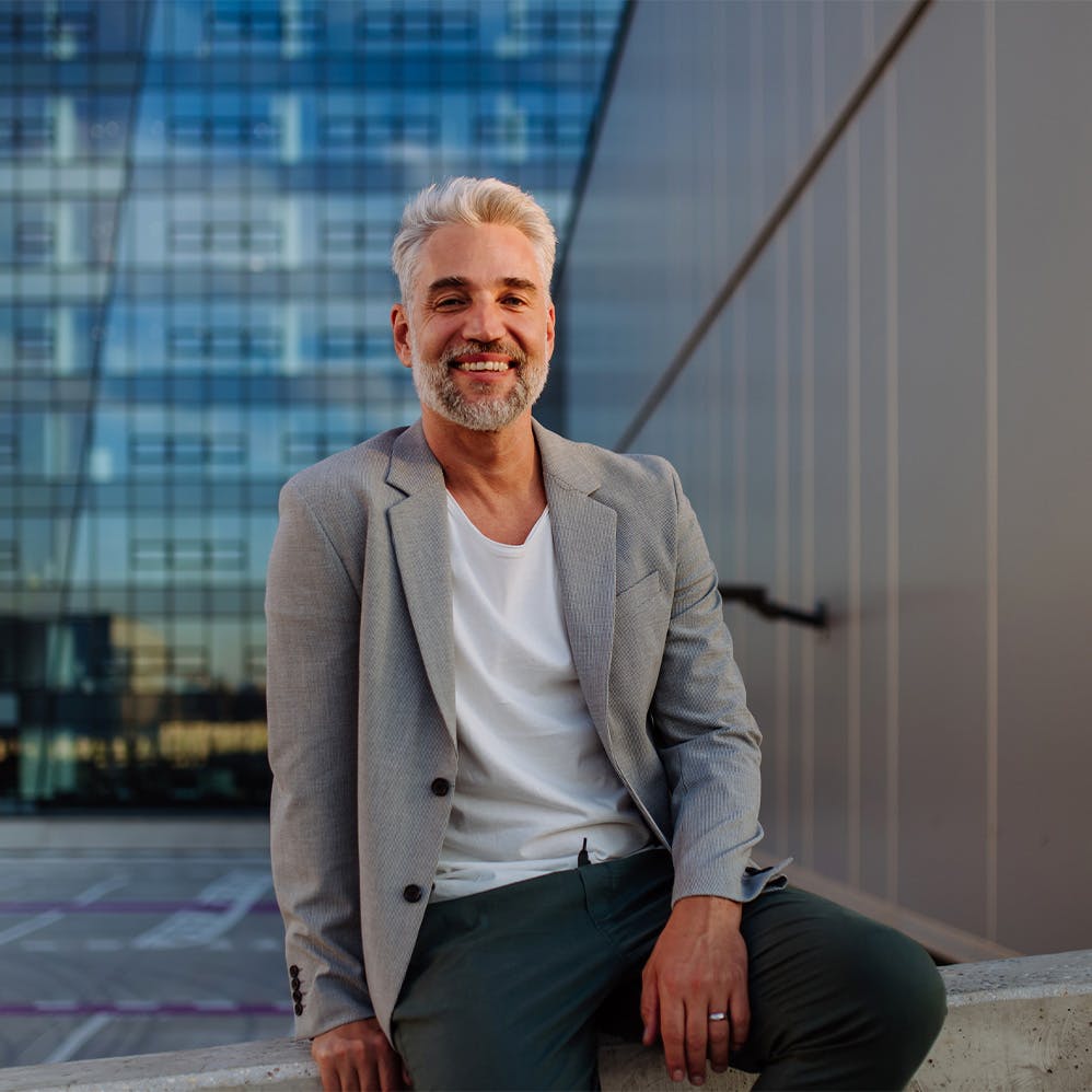 man sitting on wall near building
