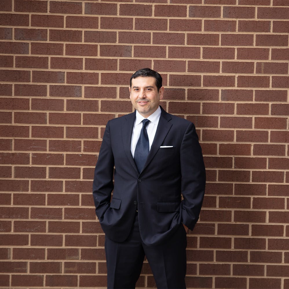Dr Hamawy standing in front of brick wall