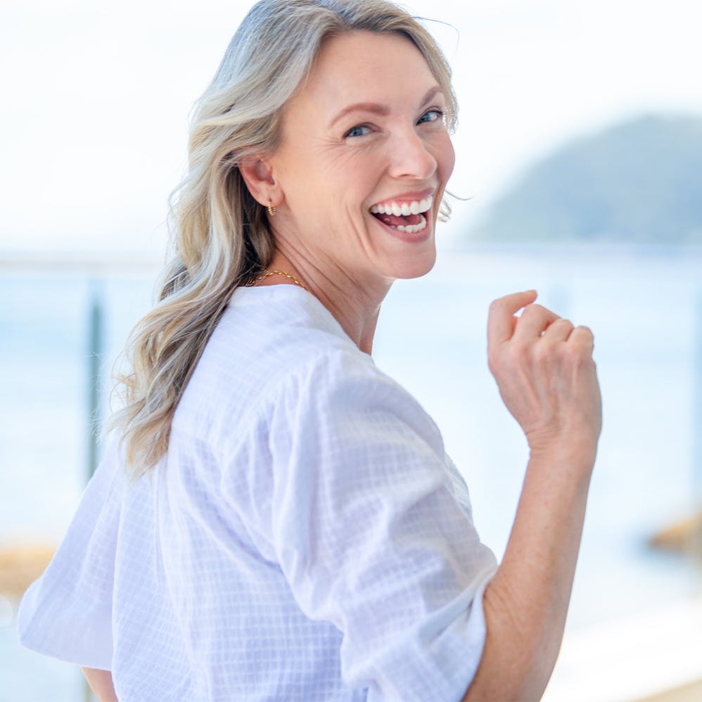 woman playfully turned away at beach