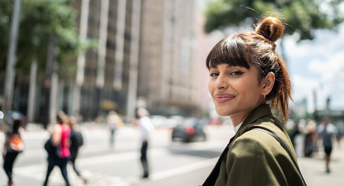 woman smiling on busy city street