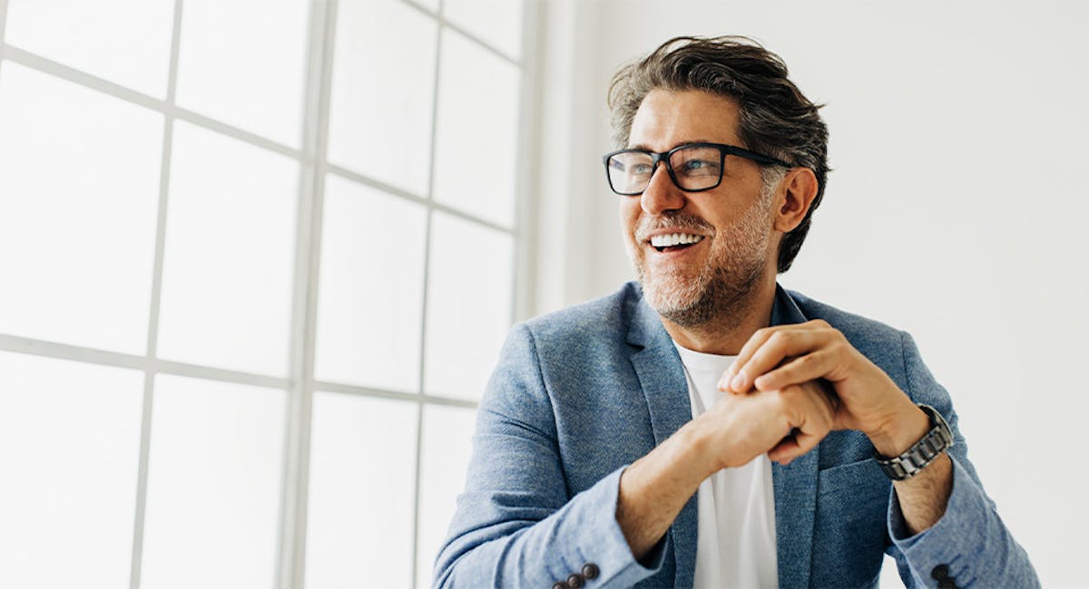 man looking out window in sports coat