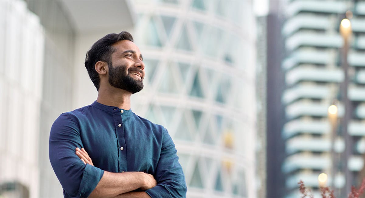 man smiling with arms crossed