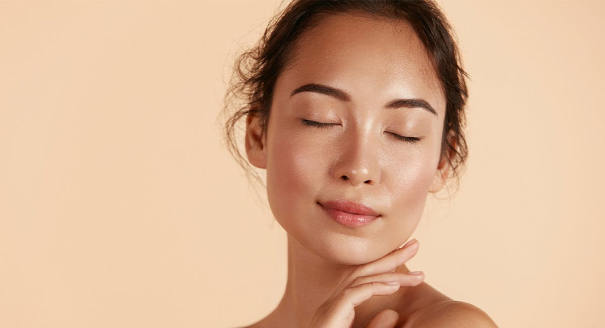 woman with eyes closed in front of orange background