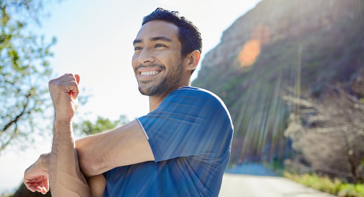 man stretching on mountain trail