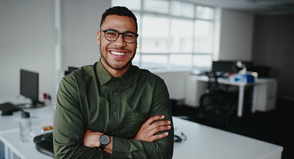 man smiling with arms crossed