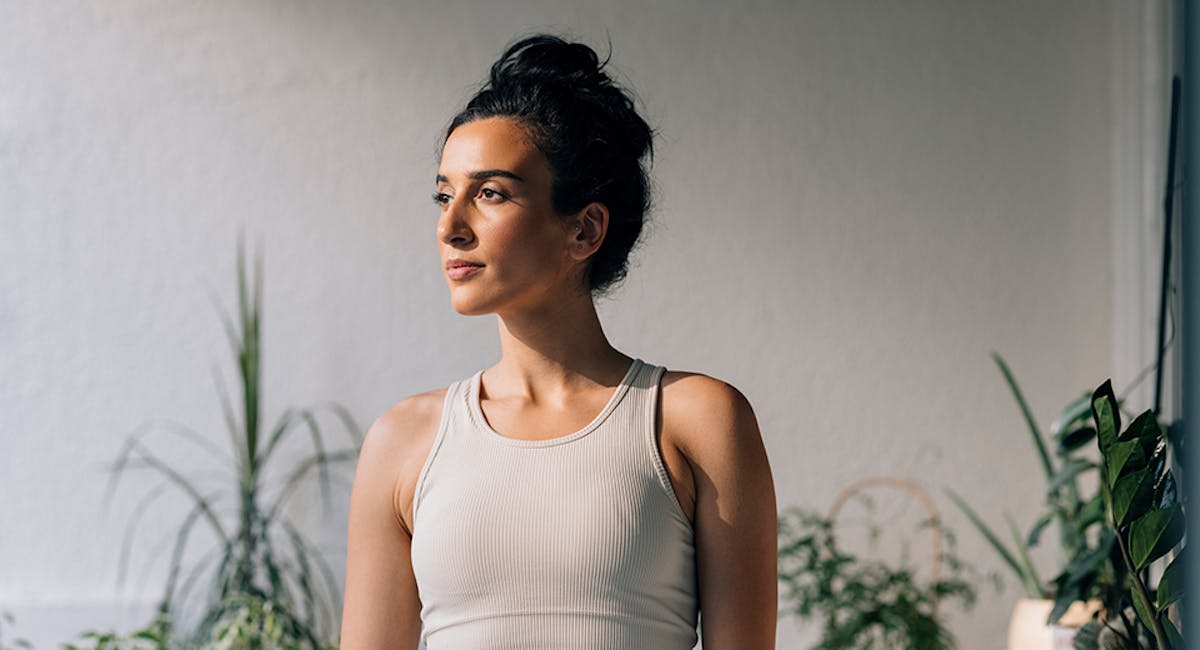 woman looking to side in front of plants