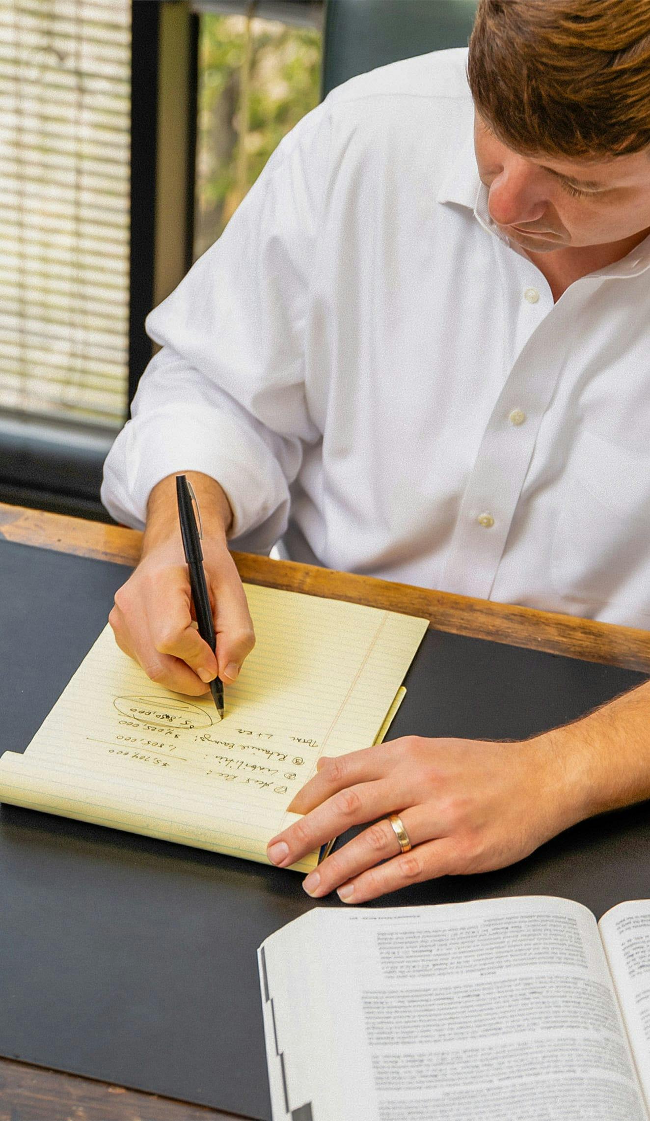 man writing on legal pad