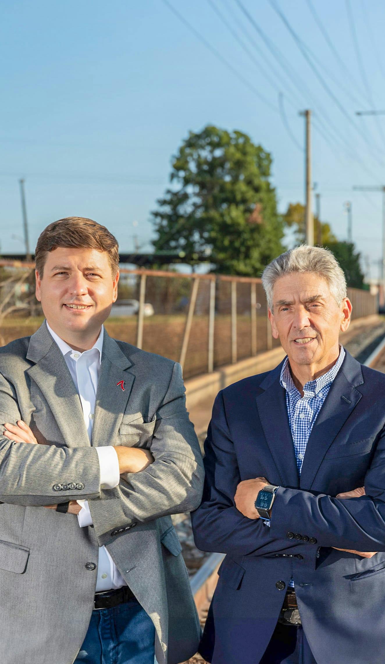 two men standing with arms crossed