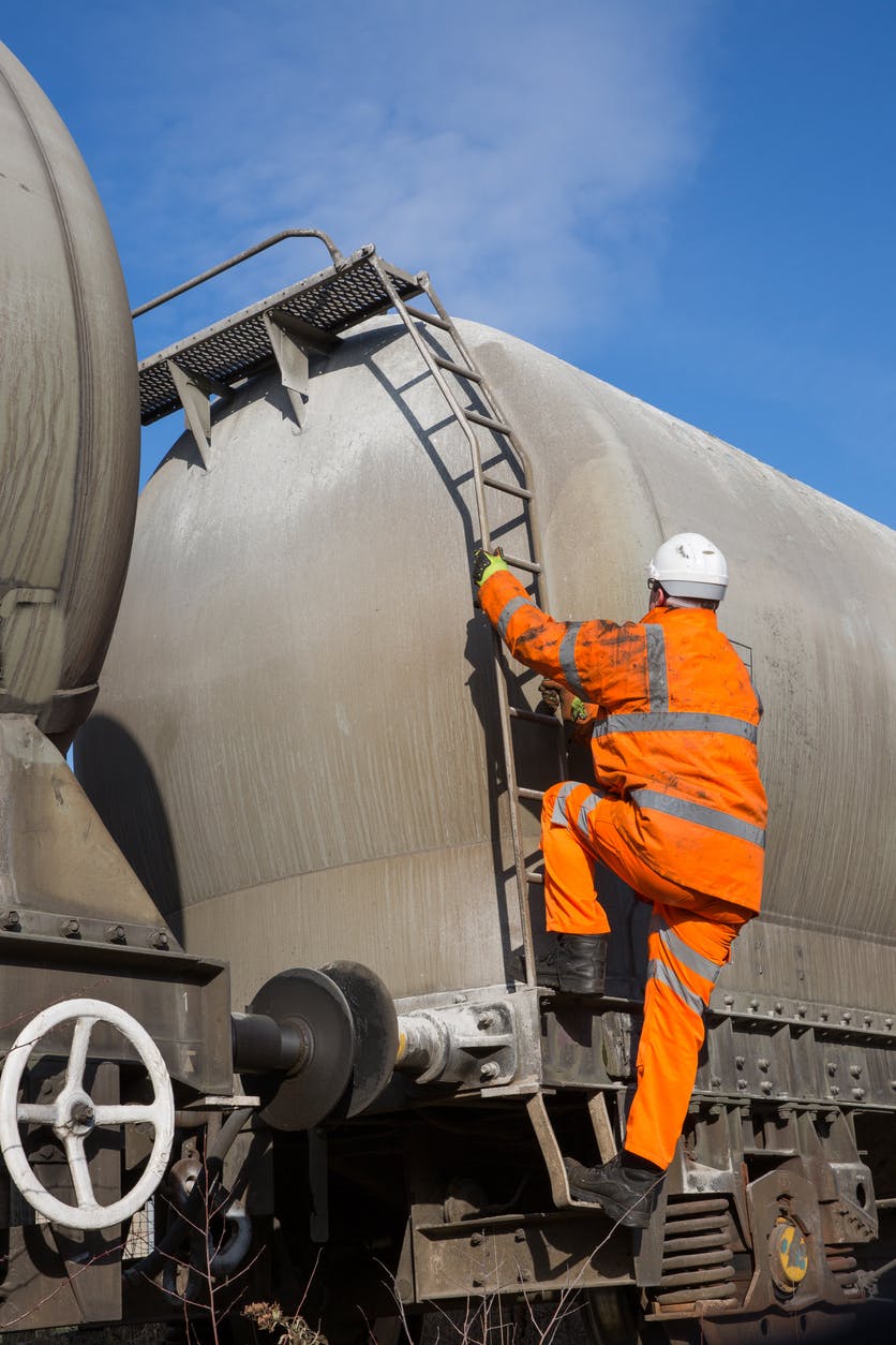A man climbing up on a railroad car