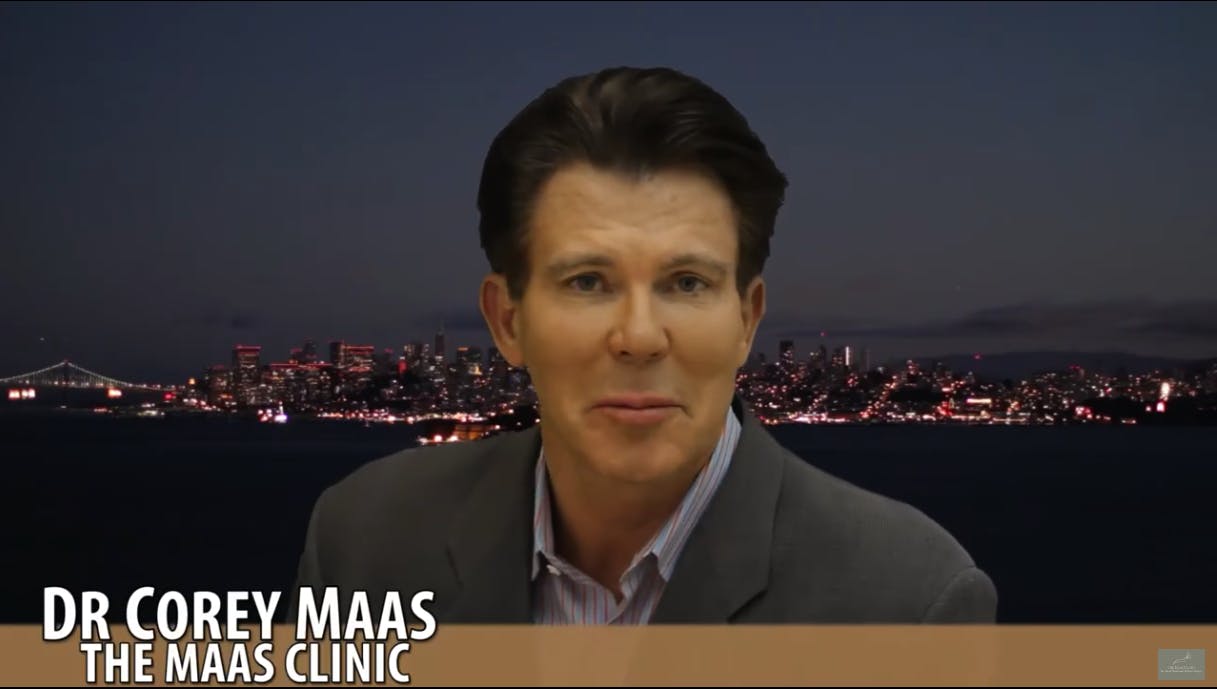 dr maas in front of a night cityscape