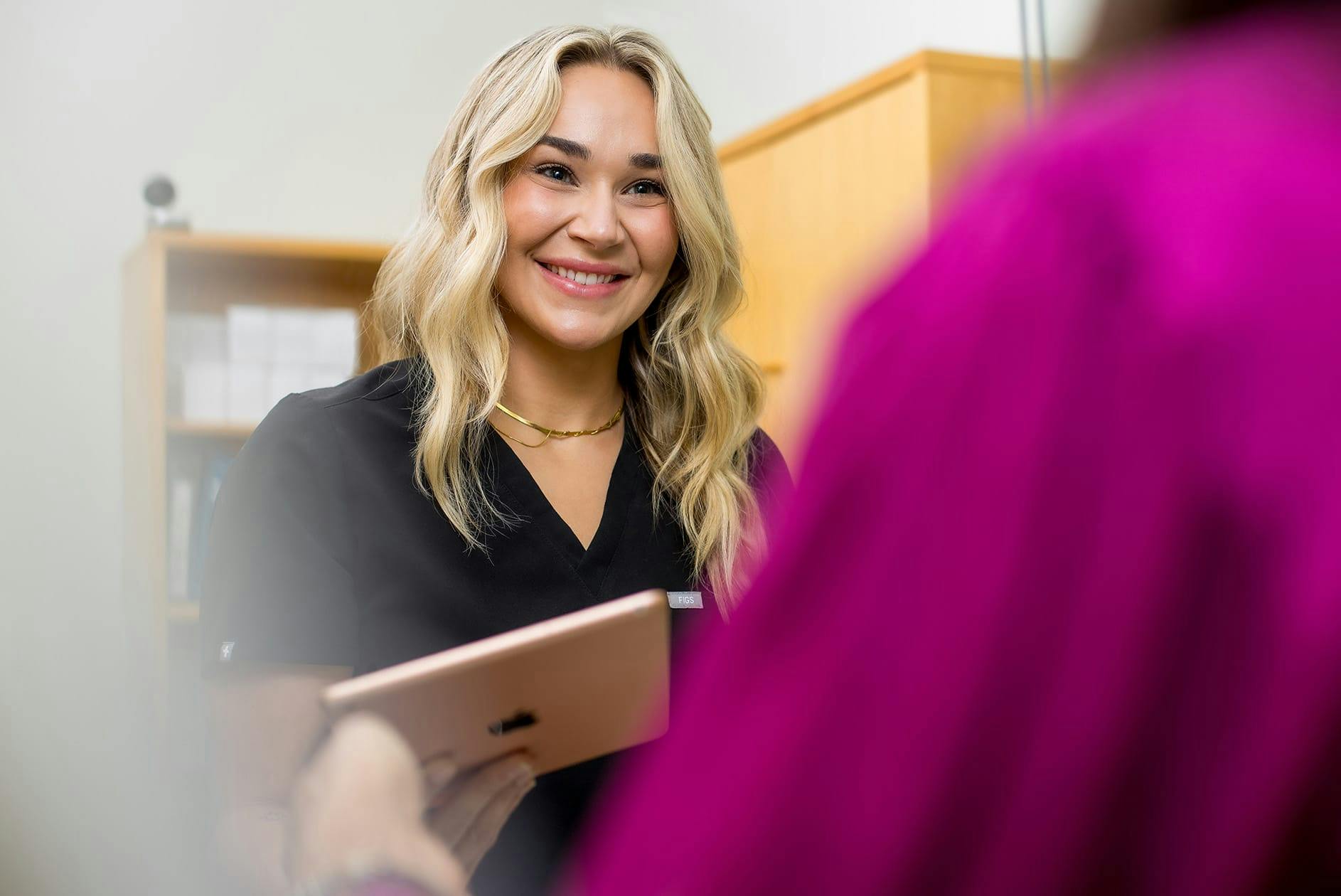 Blonde woman smiling with ipad