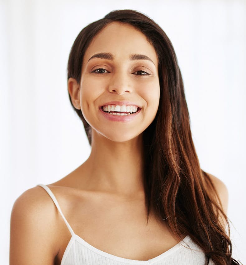 Brunette in white top smiling at camera