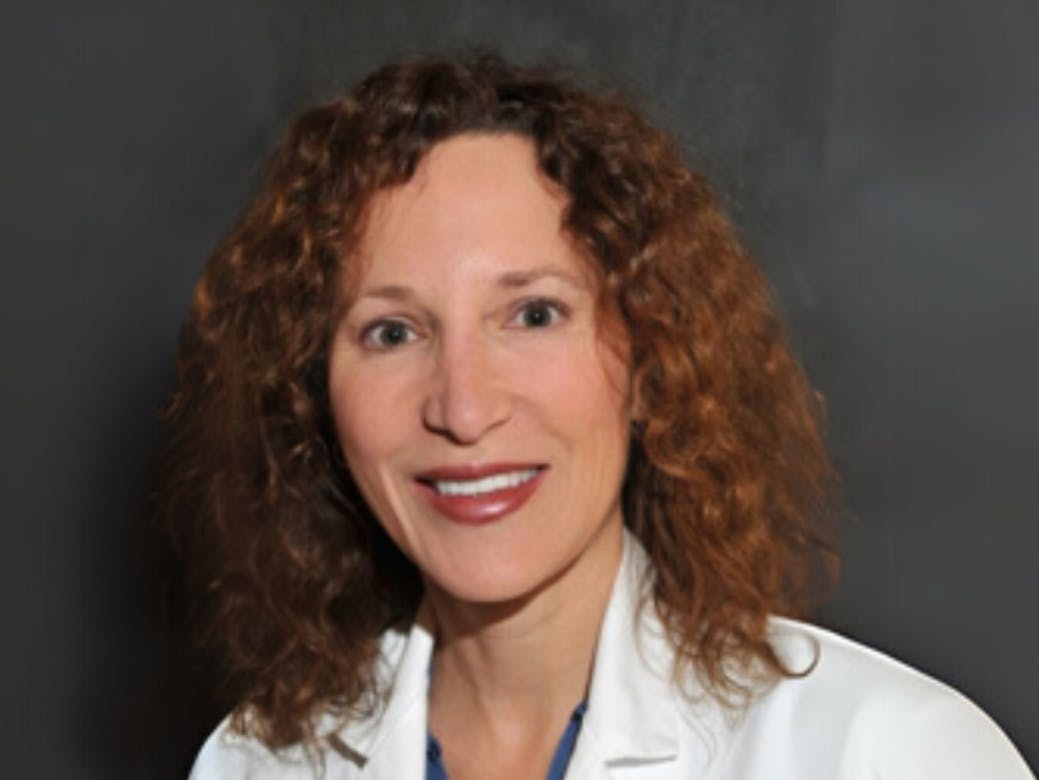 woman in white coat smiling