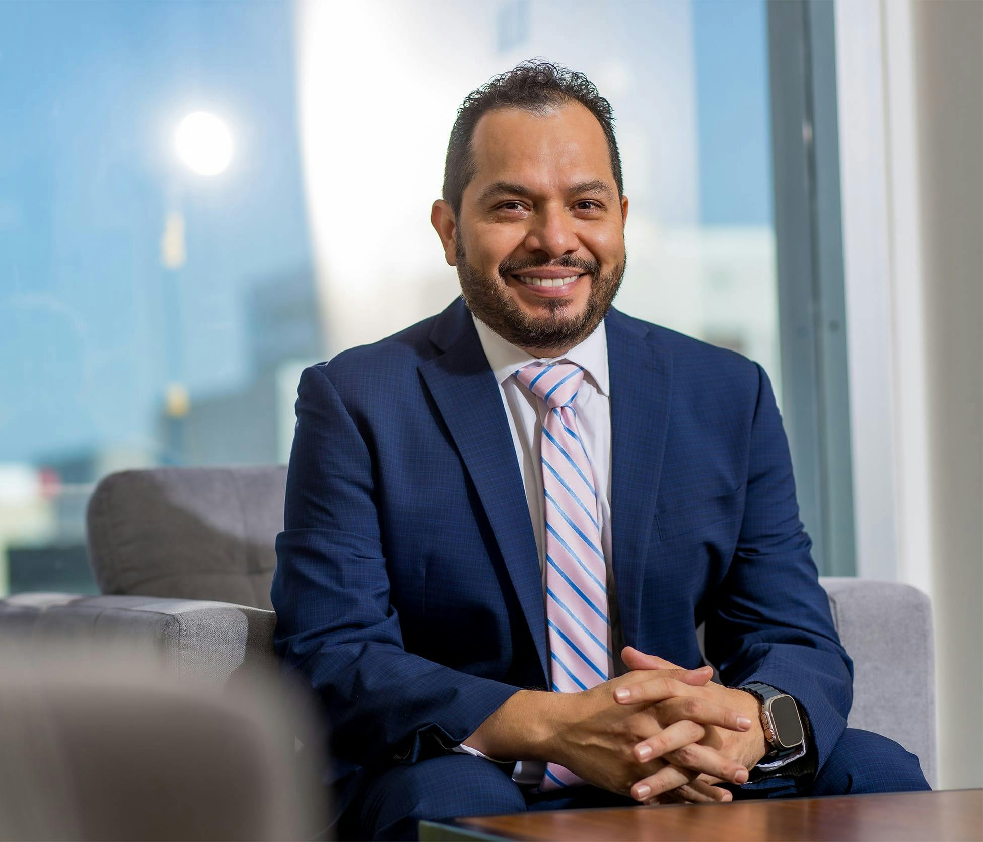 Dr. Fernando Garcia Govea Smiling in a suit sitting in chair