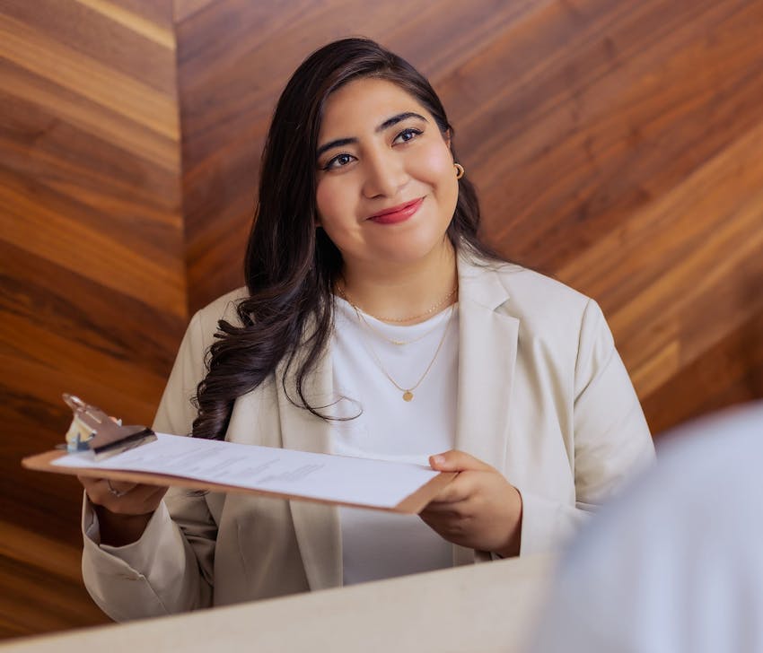 Tijuana Bariatric Center staff smiling and hand over clipboard to patient