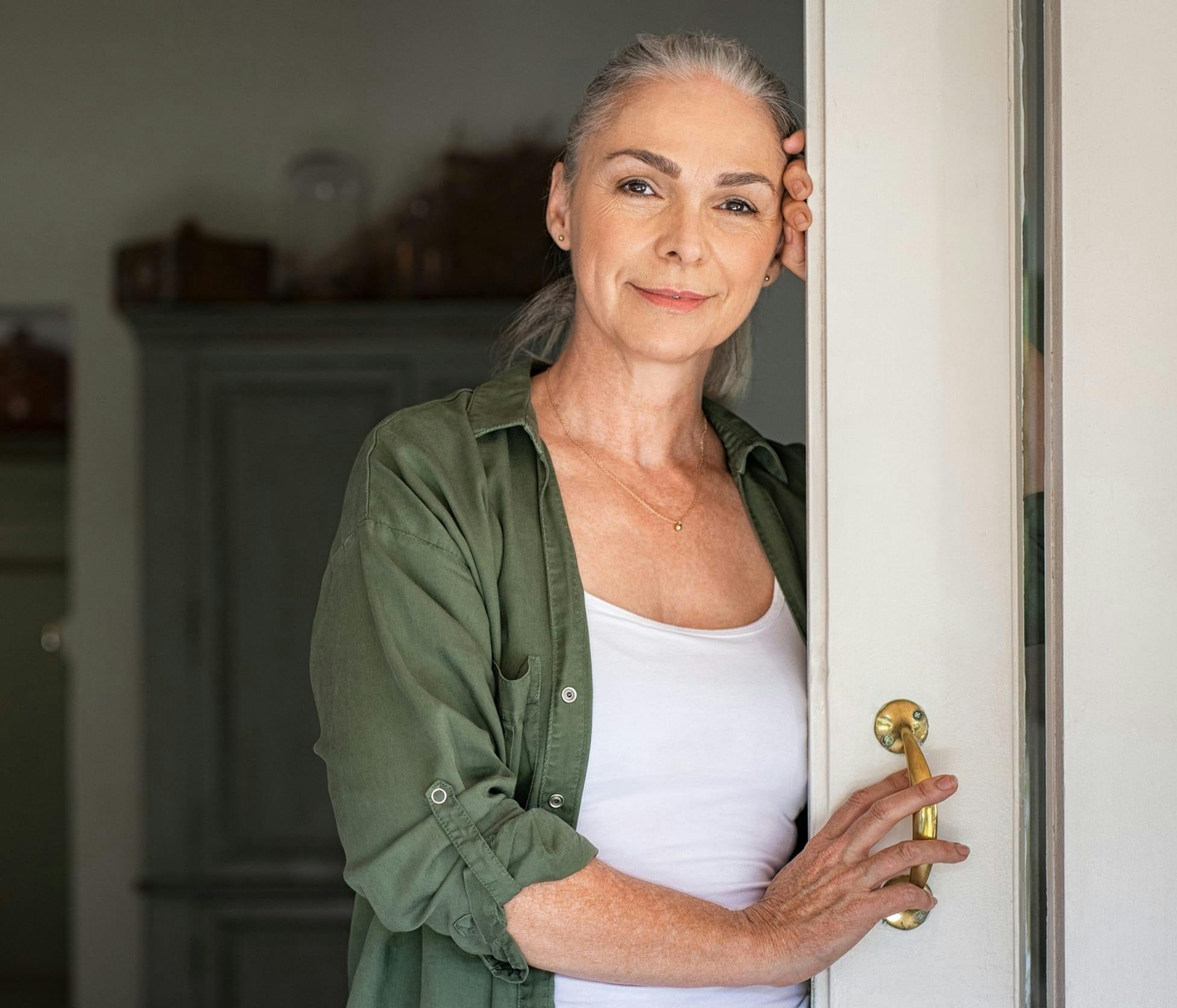 Woman smiling and leaning on door