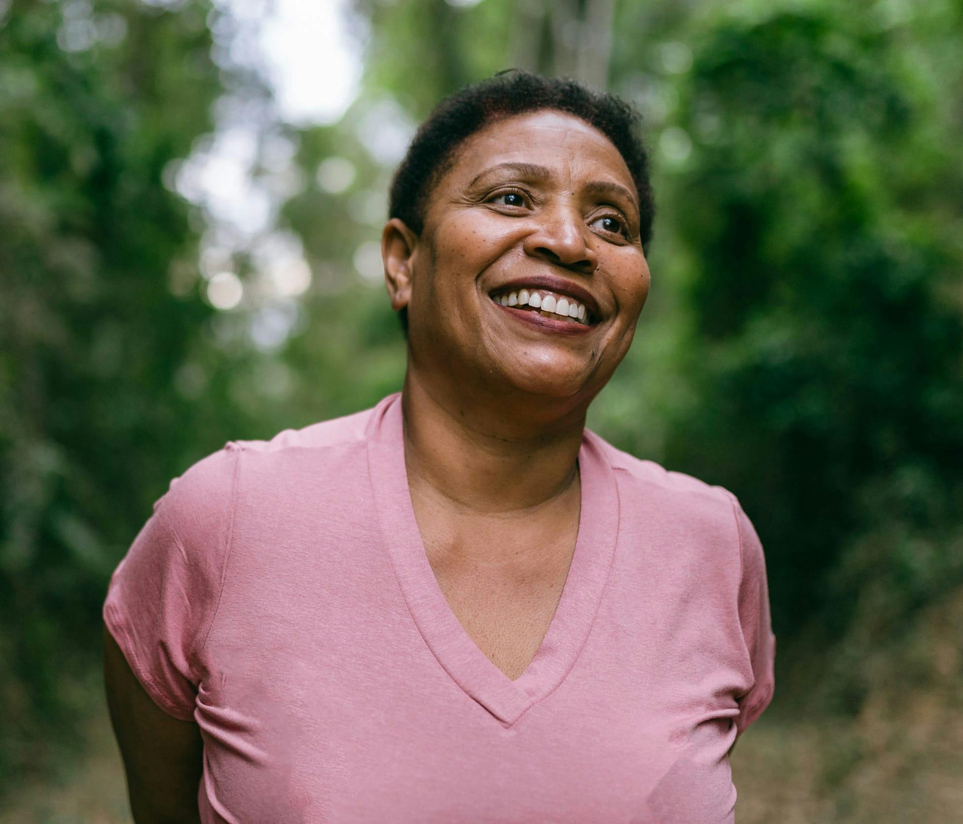 Woman smiling and taking a stroll through the woods