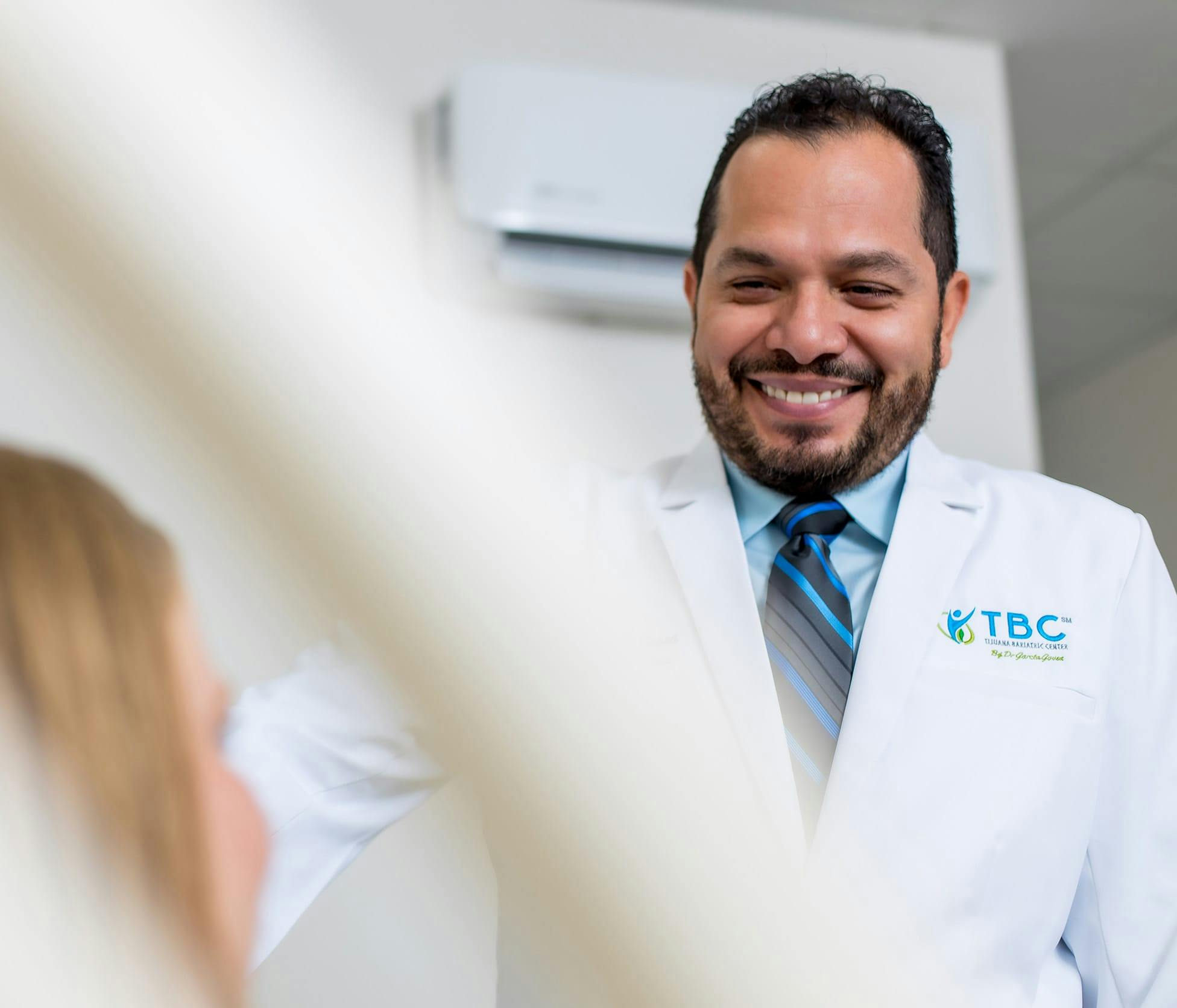 Dr. Fernando Garcia Govea Smiling and standing over patient
