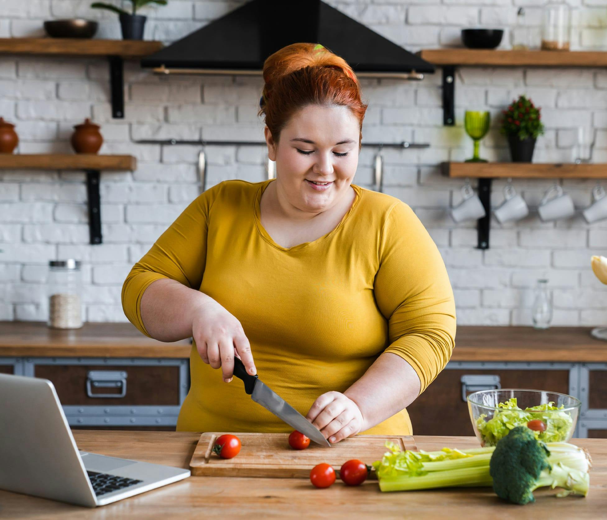 Woman smiling and cutting tomatoes