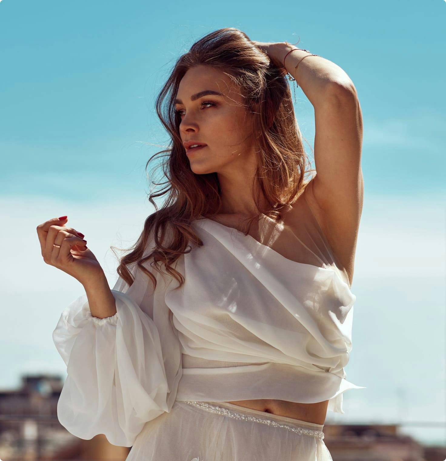 Woman in a loose white top looking to the side