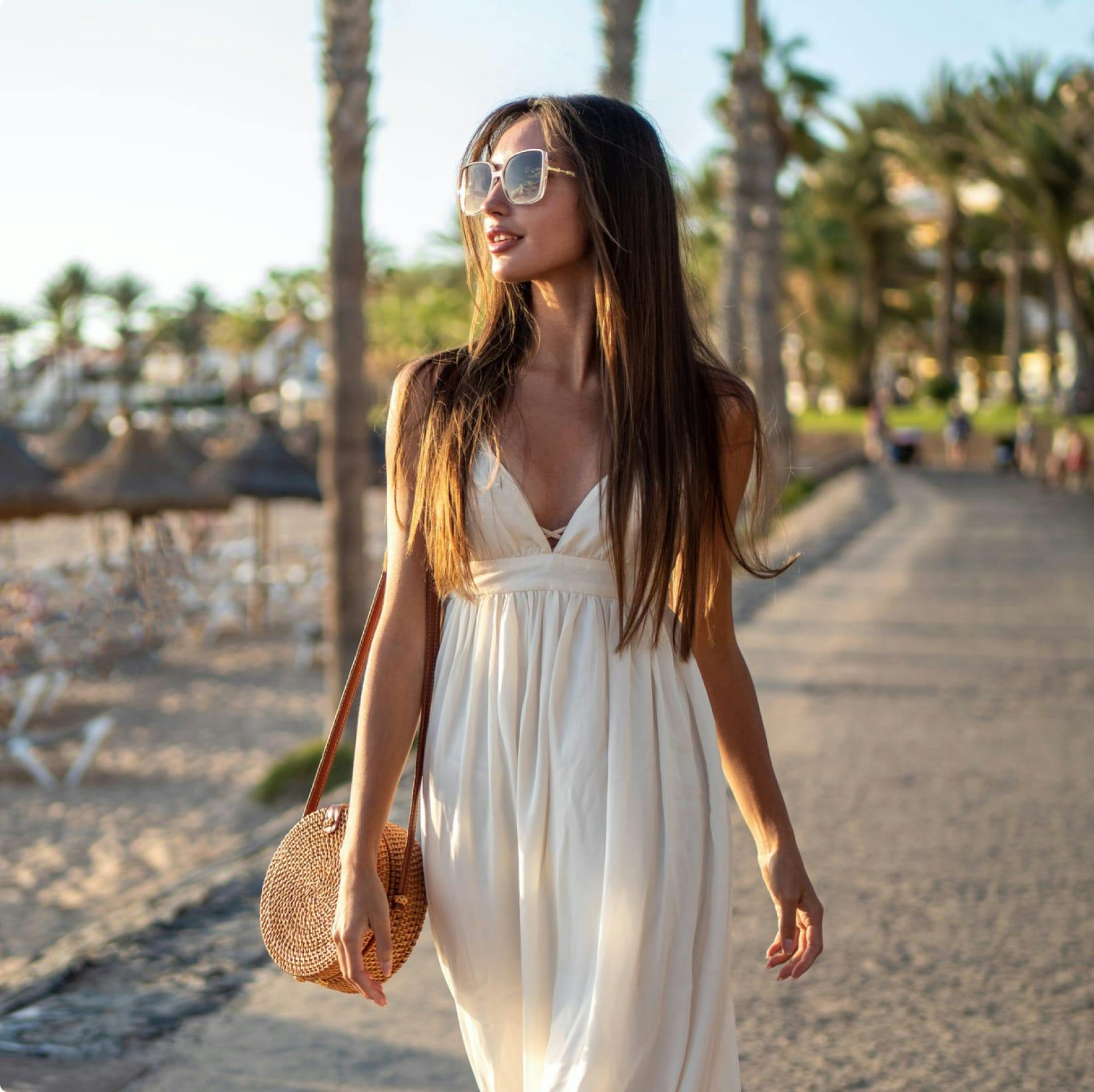 Woman in a dress walking along the beach