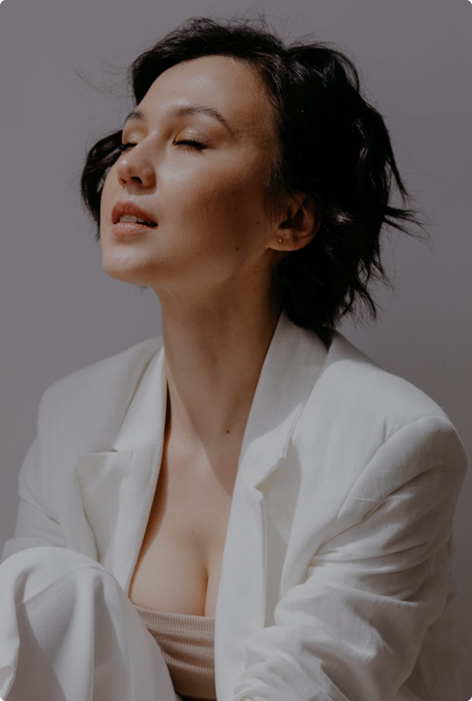 Woman in a suit jacket with her eyes closed