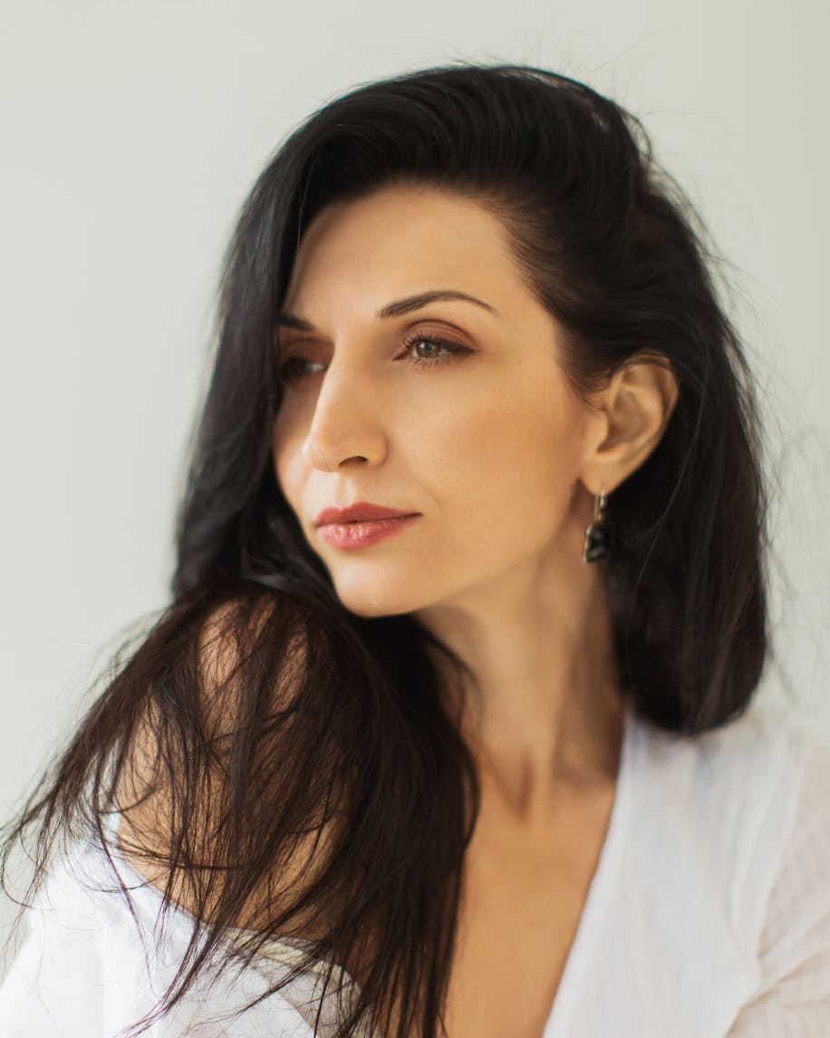 Woman in late 40's with long broan hair looks away from camera showing off her neck. This is to emulate the ptoential resutls of a Neck lift in McKinney