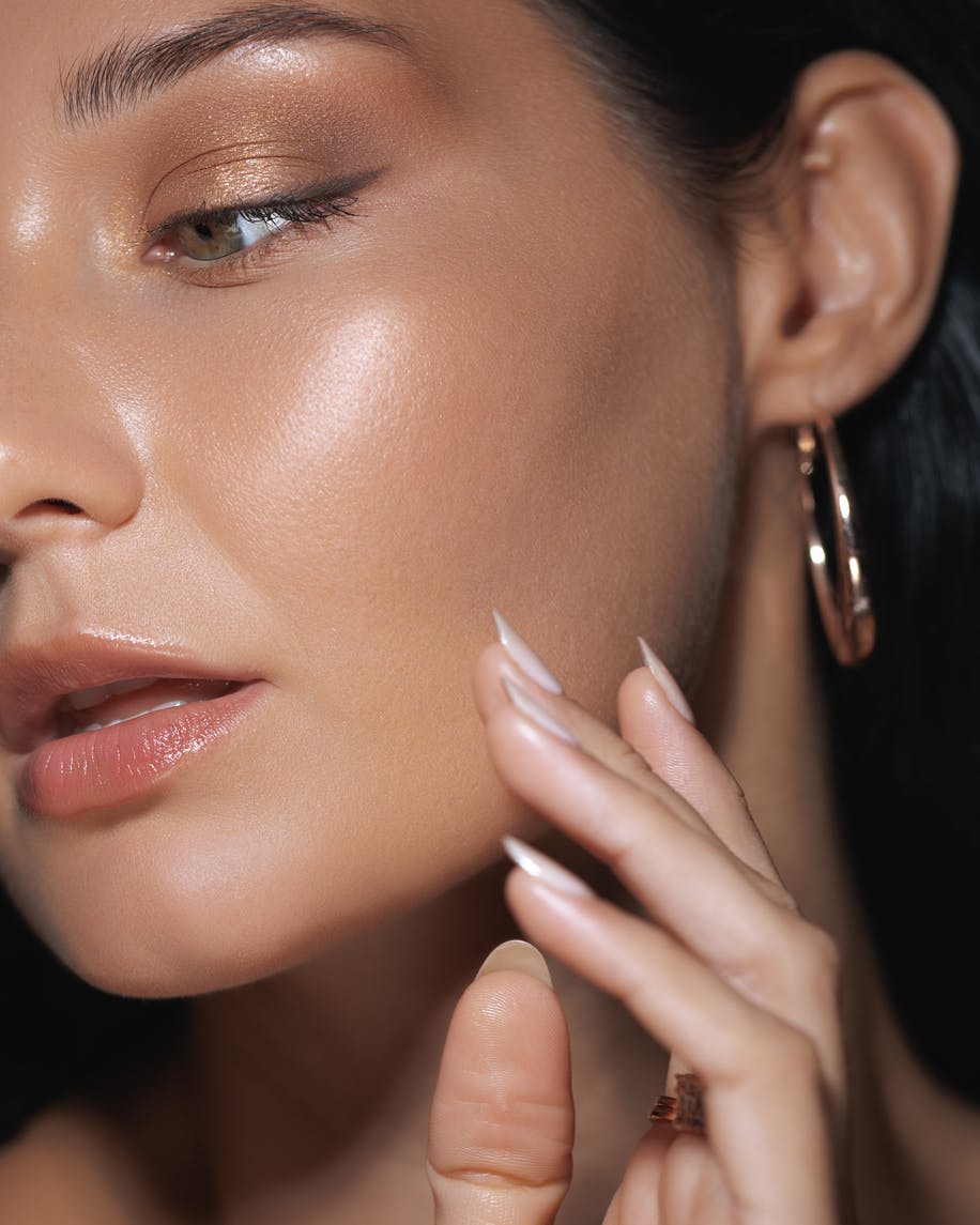 Woman with full makeup shows jaw and ear in a tight face camera shot. The attention on the ear is to show the potential results of an ear surgery in McKinney