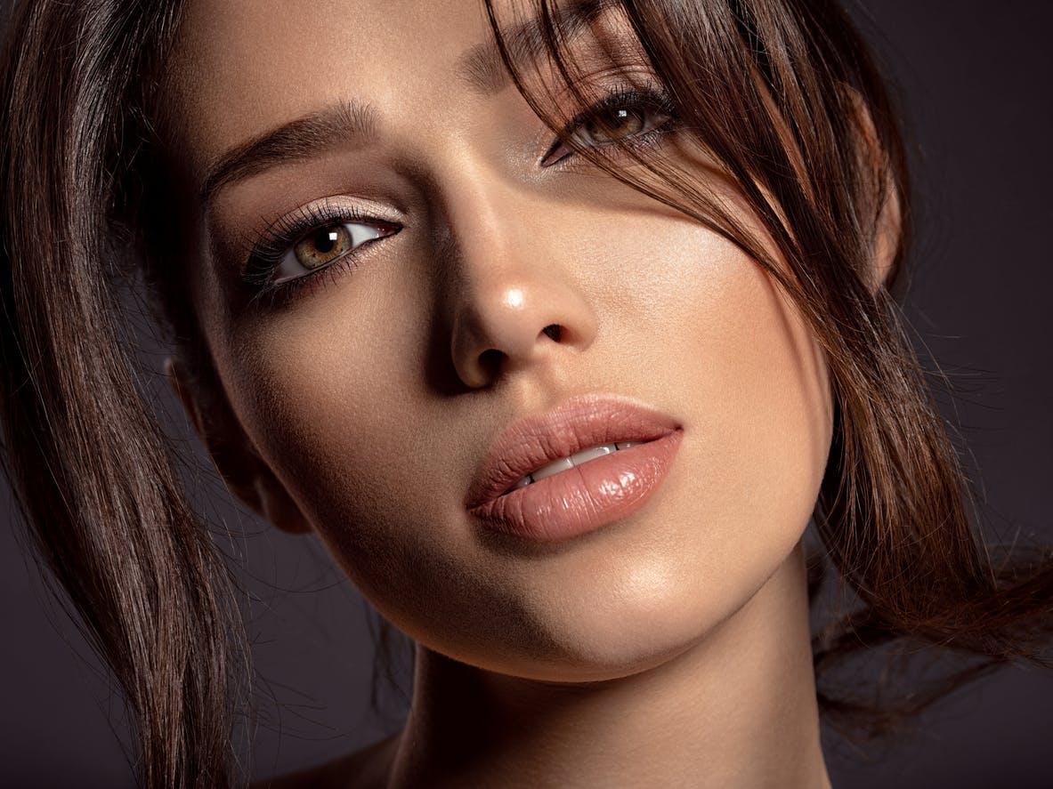 Woman with full face of makeup looking seductively at the camera. Her symmetrical face is to show the potential results of a chin augmentationin McKinney
