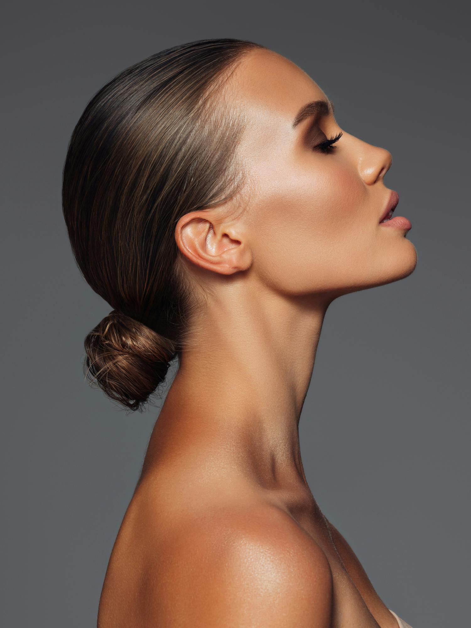 Profile shot of a young woman with hair slciked back to show off the contour of her jawline. This is to emulate the buccal fat removal in McKinney with Setty Plastics and Aesthetics