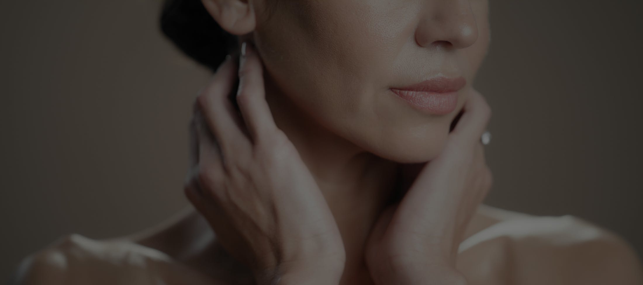 Woman with hands near neck and tight neck skin shows possible results of a neck liposuction in McKinney