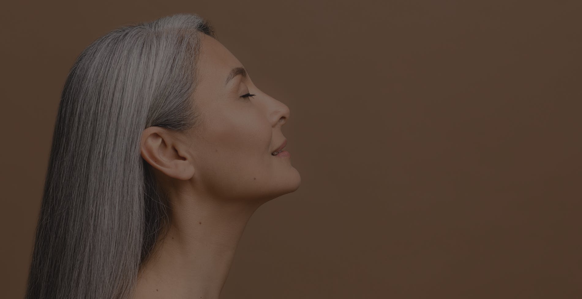 Woman looks up to show her tight neck skin. This is to show the possible results of a neck liposuction in McKinney