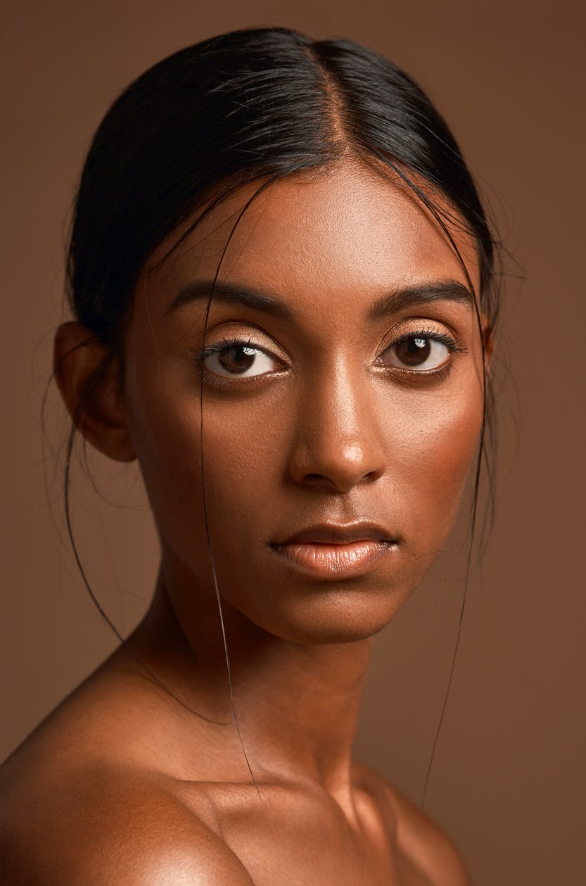 Woman with hair tied back and glowing skin