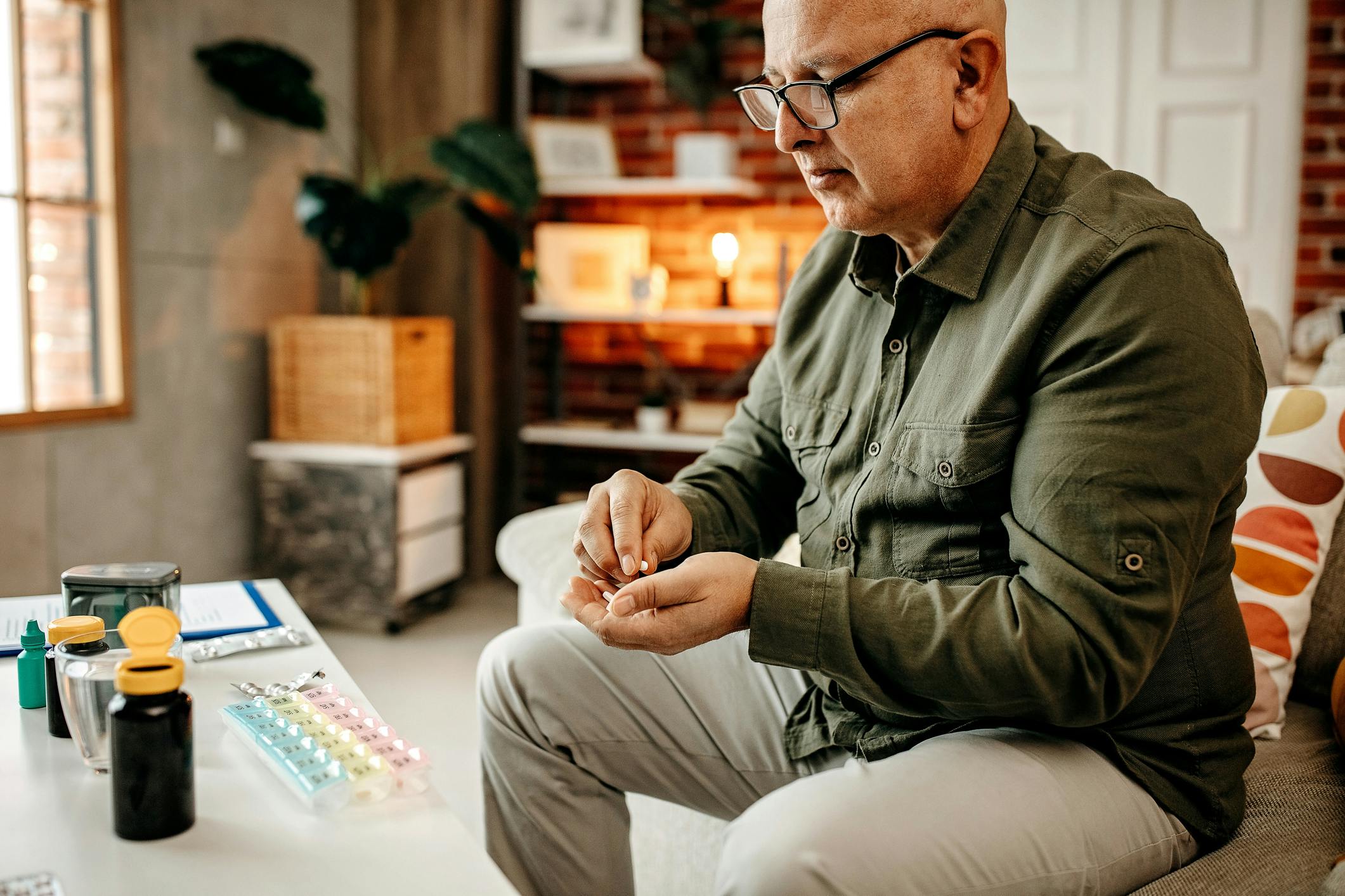 man in green shirt checking his prescription pills