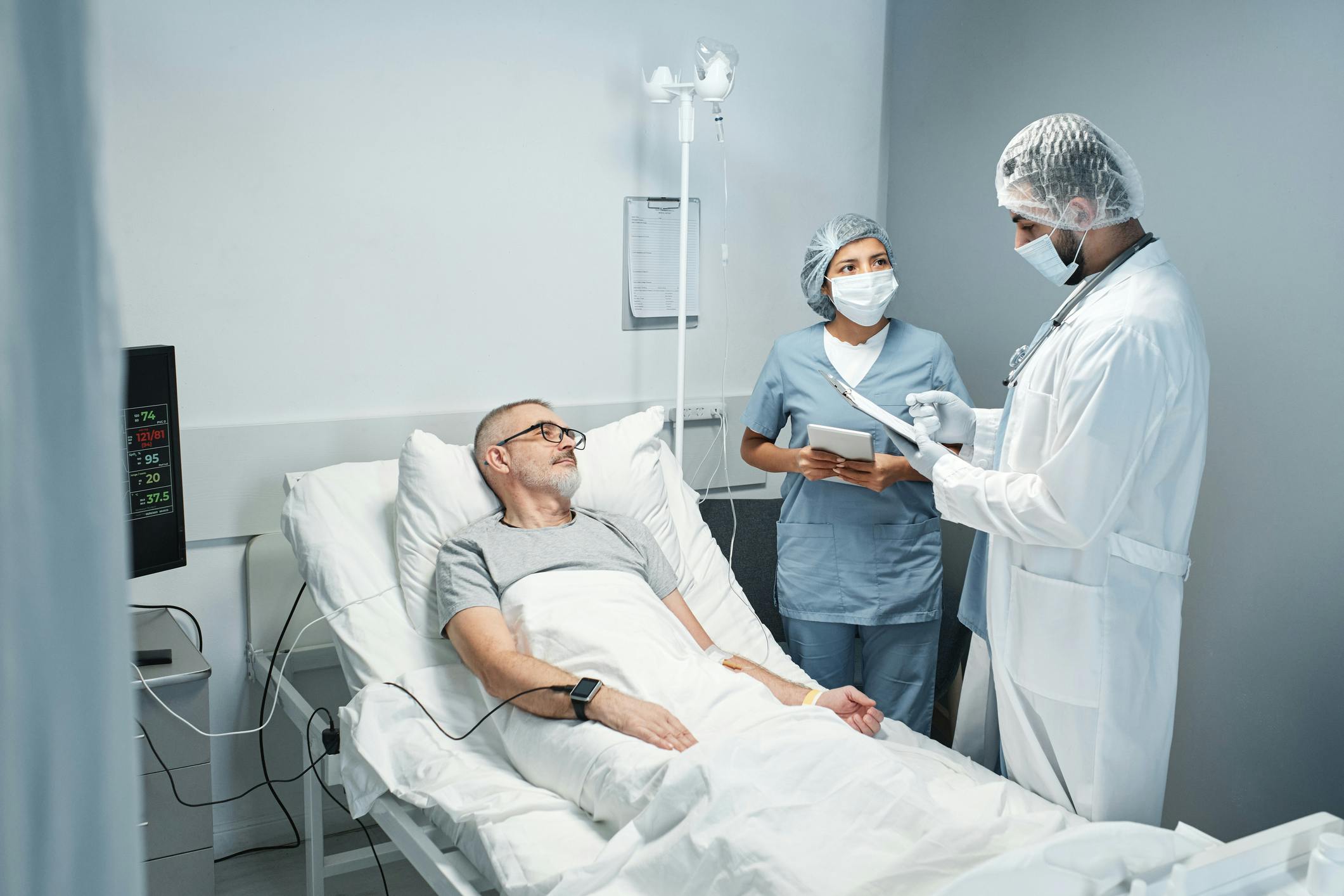 male on operating table being consulted by doctors