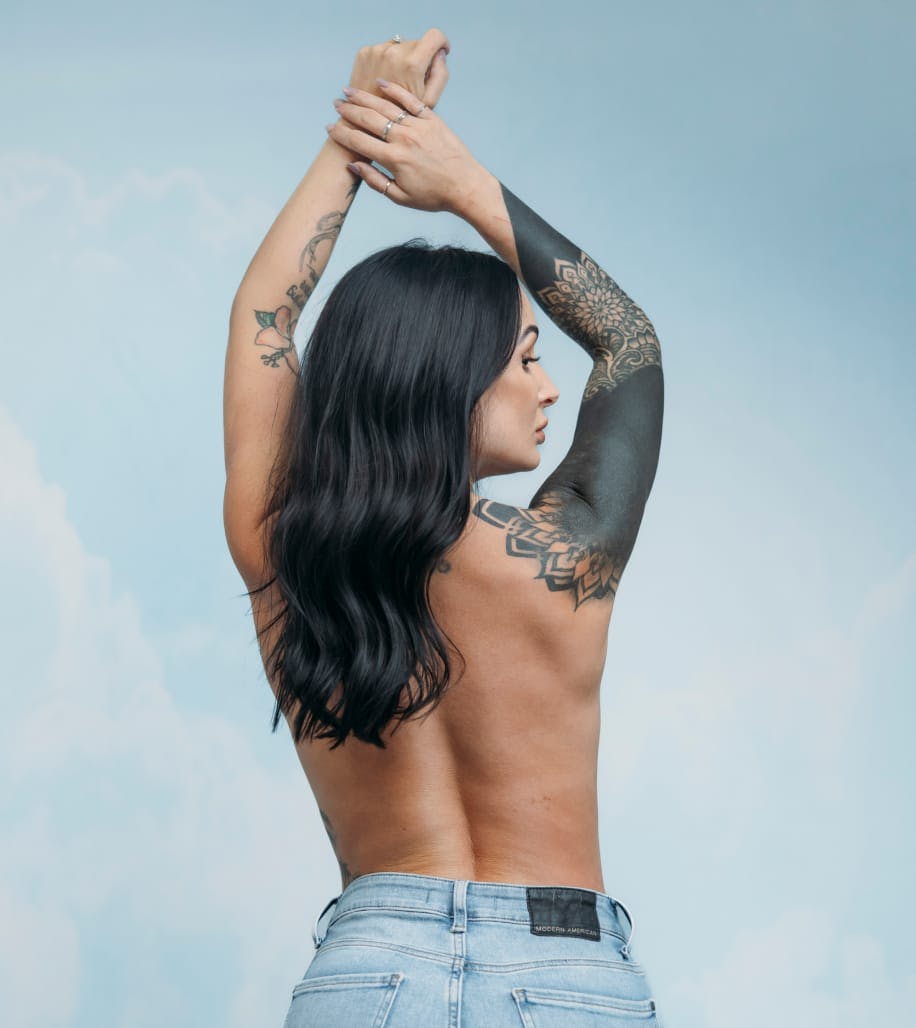 shirtless woman's back with her arms raised up above her head