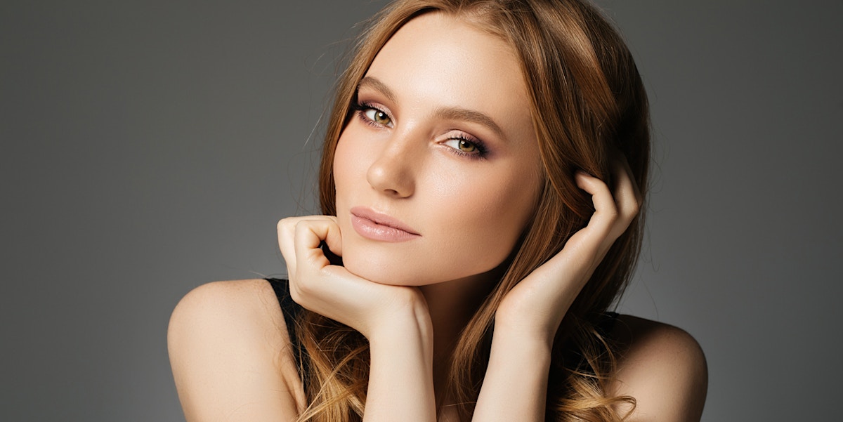 Woman with a beautiful wrinkle free face, has a small smile while looking at the camera in a portrait shoot, showing the potential results of BOTOX in Orlando FL