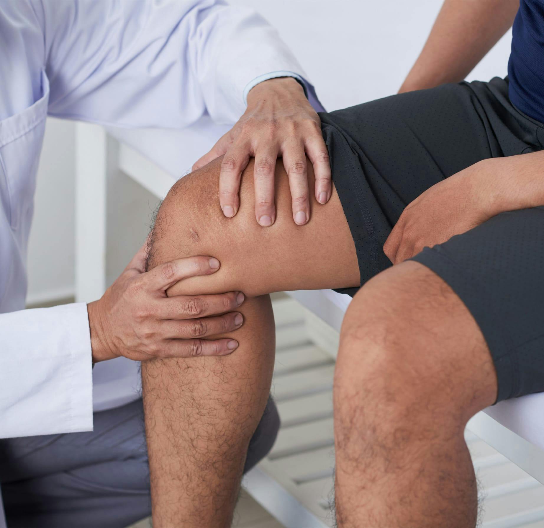 doctor feeling a patient's knee