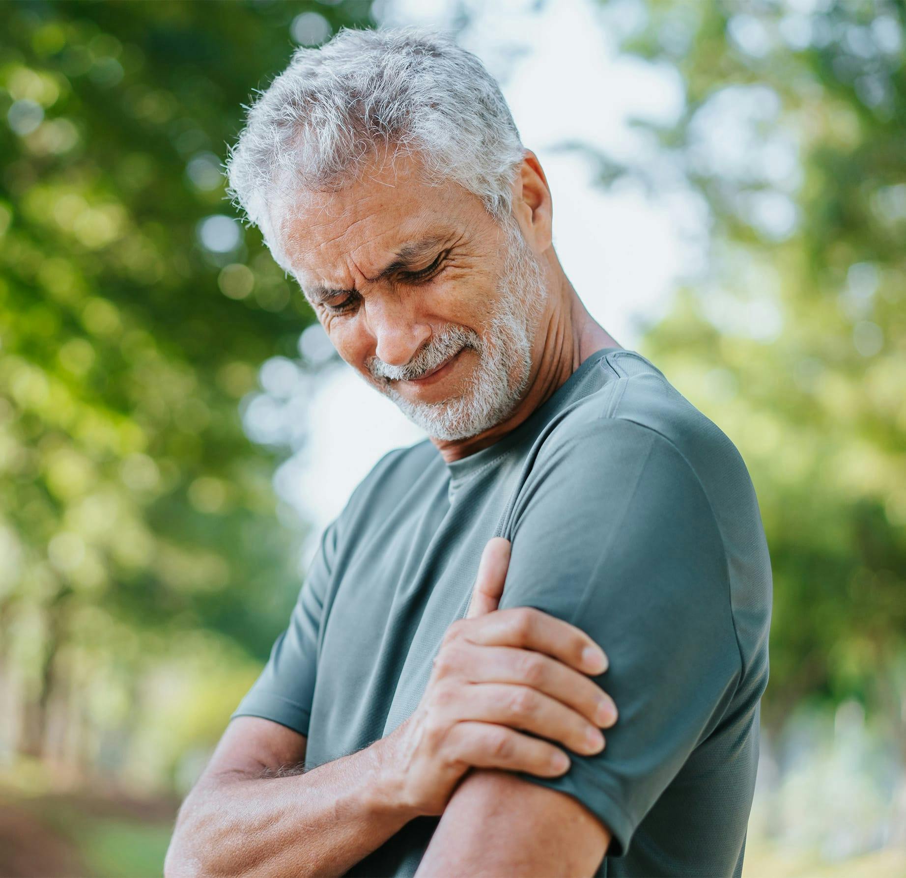 older man holding his arm in pain