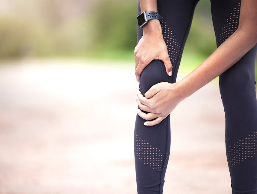 woman holding her knee