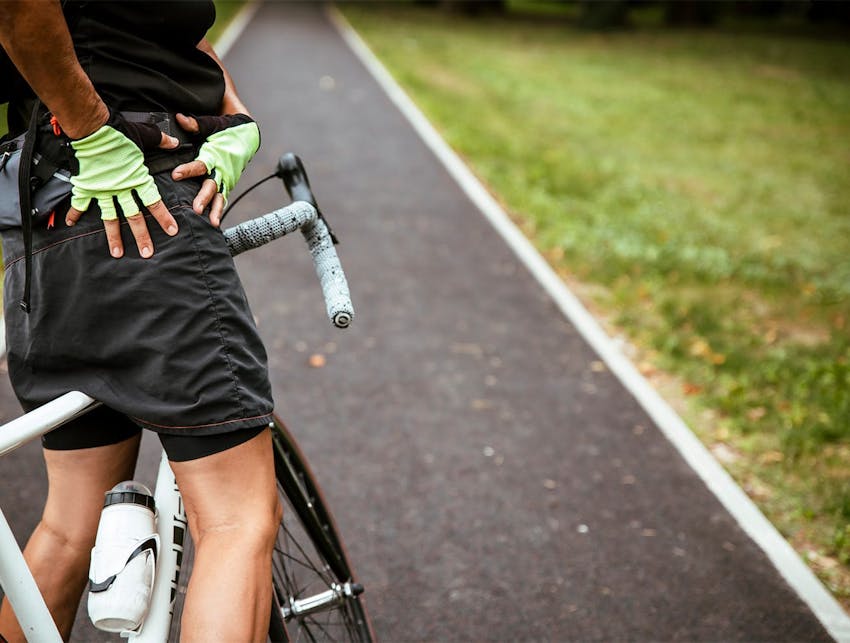 man on a bike holding his hip
