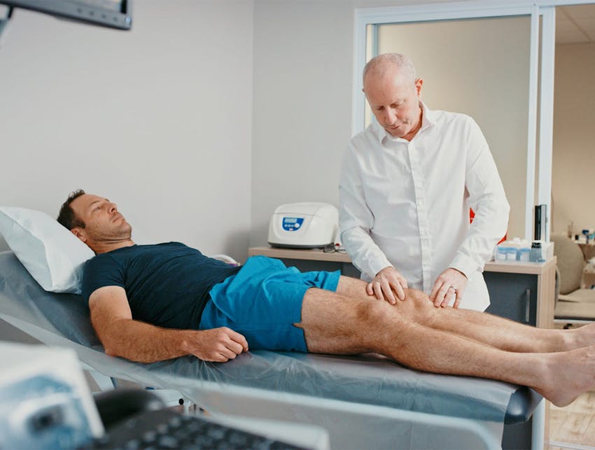 man touching a patient's leg