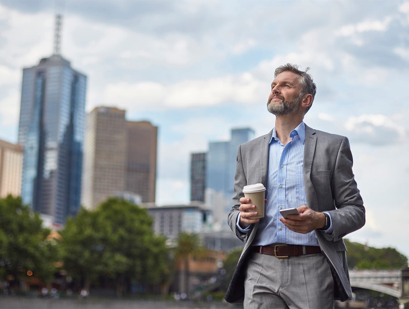 man walking down the street with coffee