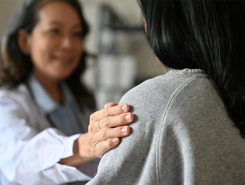 doctor touching patient's shoulder