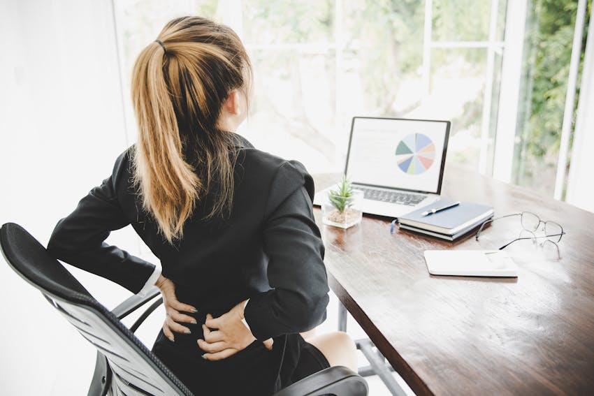 Woman with back pain at a desk